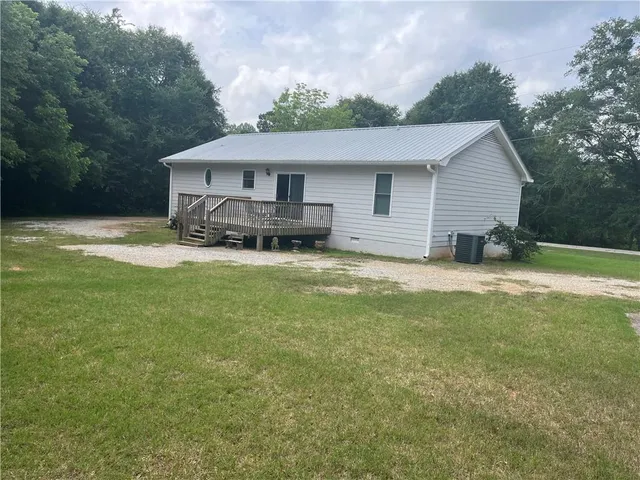 a view of a house with a big yard and large trees