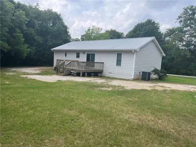a view of a house with a big yard and large trees