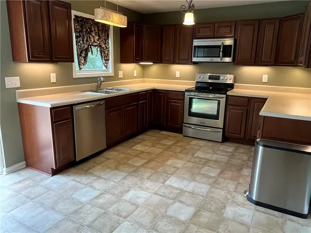 a kitchen with stainless steel appliances granite countertop a stove a sink dishwasher and a refrigerator