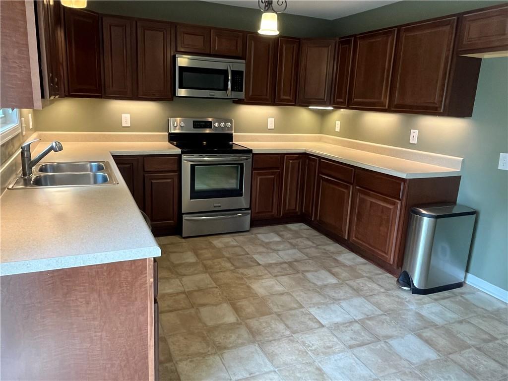1429 Thyatira Brockton Road Jefferson, GA 30549 - Photo 10 of 46 a kitchen with granite countertop a sink a stove top oven and wooden cabinetry