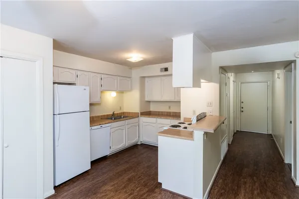 a room with stainless steel appliances a refrigerator and a stove top oven