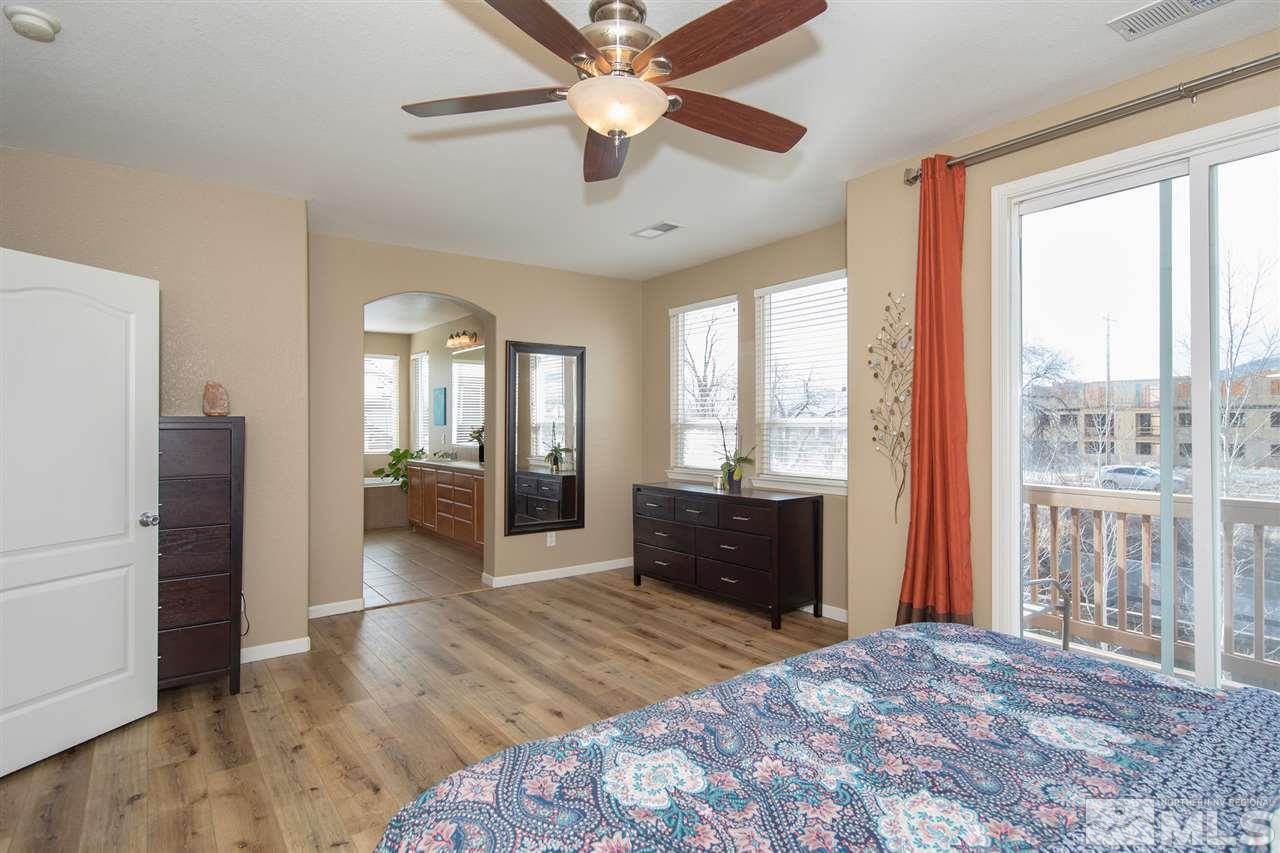 400 Parade Drive Reno, NV 89521 - Photo 12 of 24 a bedroom with a bed large mirror and a large window