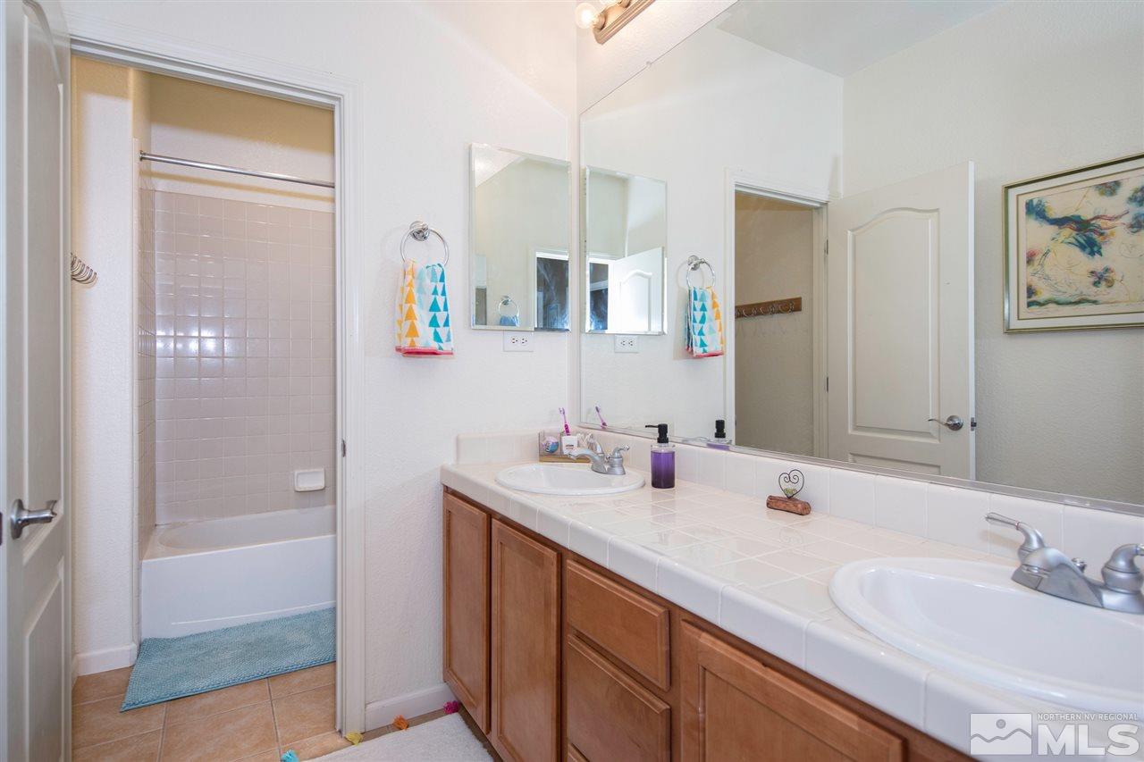 400 Parade Drive Reno, NV 89521 - Photo 16 of 24 a bathroom with a sink double vanity and a shower