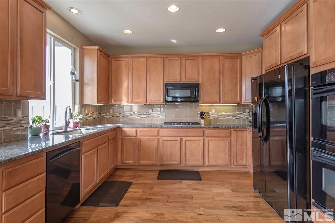 400 Parade Drive Reno, NV 89521 - Photo 4 of 24 a kitchen with stainless steel appliances granite countertop a refrigerator sink and cabinets