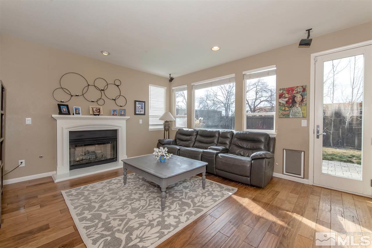 400 Parade Drive Reno, NV 89521 - Photo 8 of 24 a living room with furniture a fireplace and a floor to ceiling window