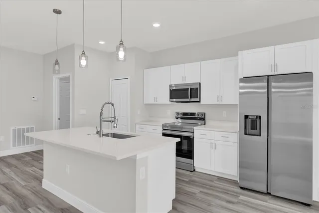 a kitchen with stainless steel appliances a refrigerator sink and microwave