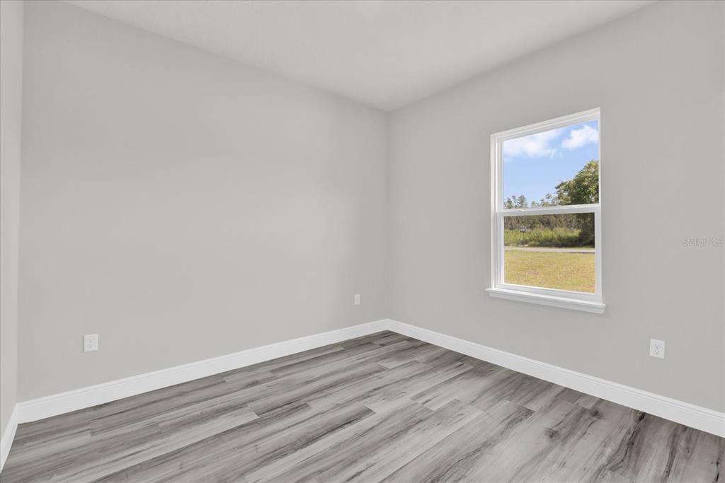 15684 Southwest 37th Circle Ocala, FL 34473 - Photo 16 of 34 a view of an empty room with wooden floor and a window