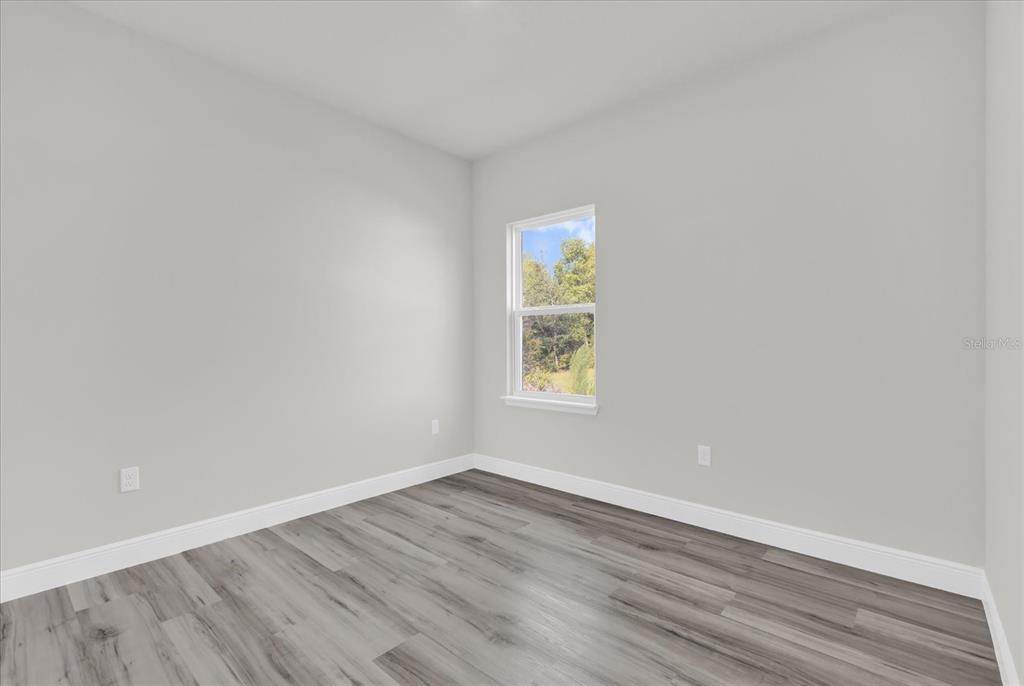 15684 Southwest 37th Circle Ocala, FL 34473 - Photo 23 of 34 an empty room with wooden floor and windows