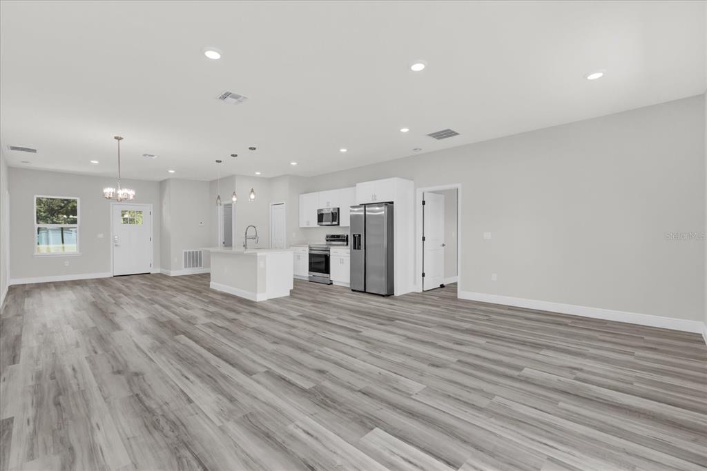 15684 Southwest 37th Circle Ocala, FL 34473 - Photo 7 of 34 a view of an empty room with wooden floor