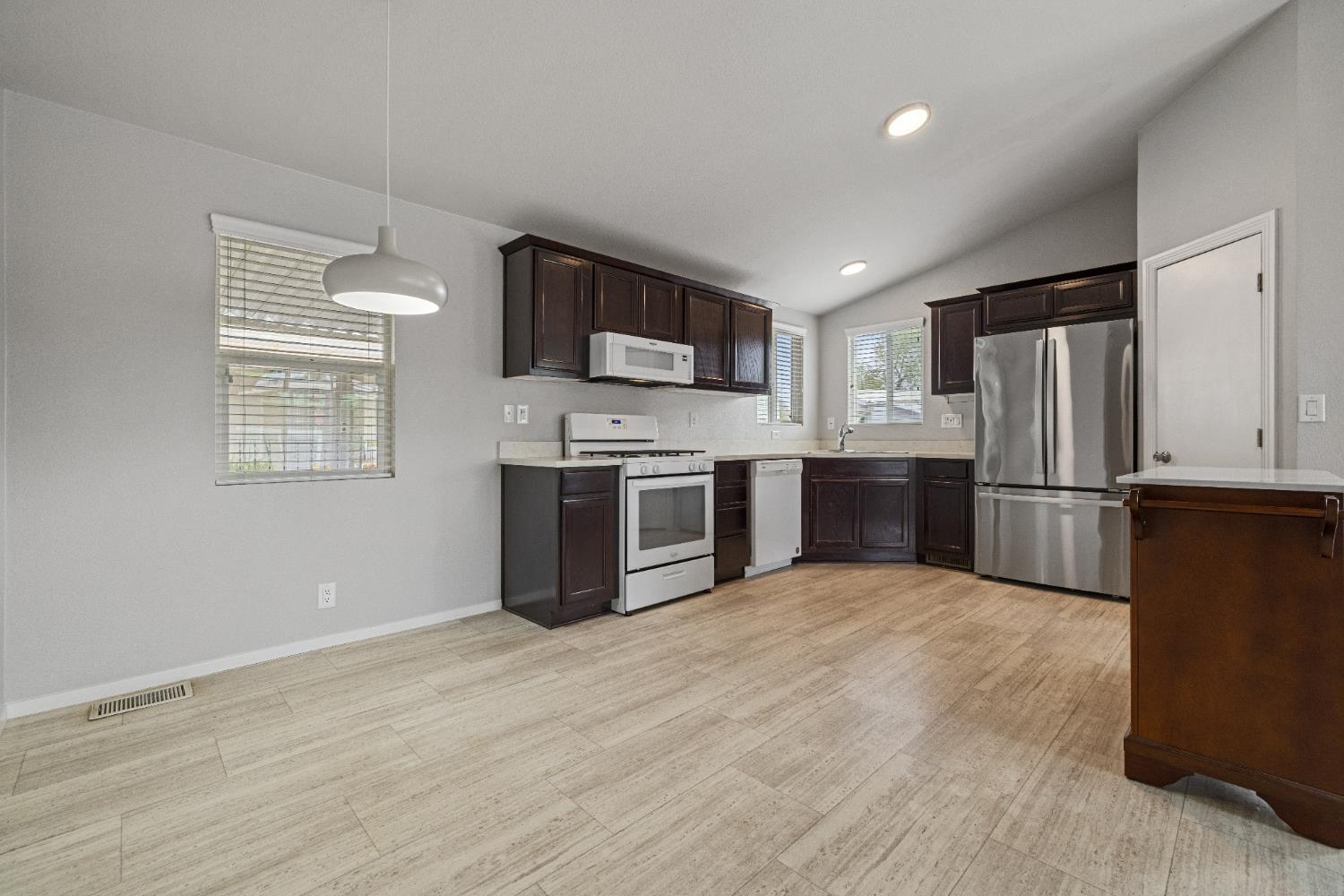 2621 Prescott, Unit 92 Modesto, CA 95350 - Photo 9 of 25 a kitchen with stainless steel appliances granite countertop a refrigerator stove a sink and a dishwasher with wooden floor