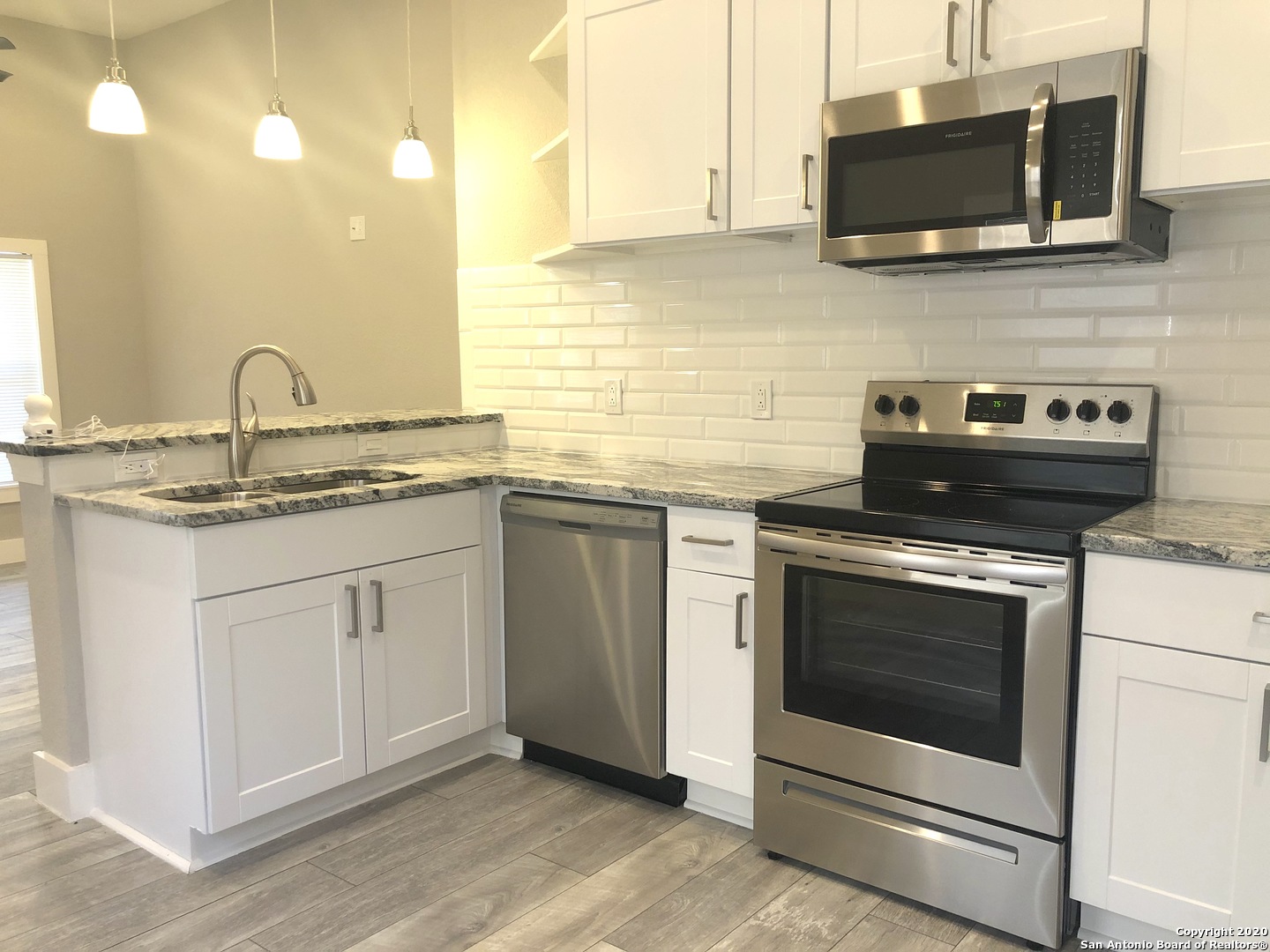 603 Devine Street, Unit 2 San Antonio, TX 78210 - Photo 6 of 16 a kitchen with stainless steel appliances granite countertop a stove and a microwave