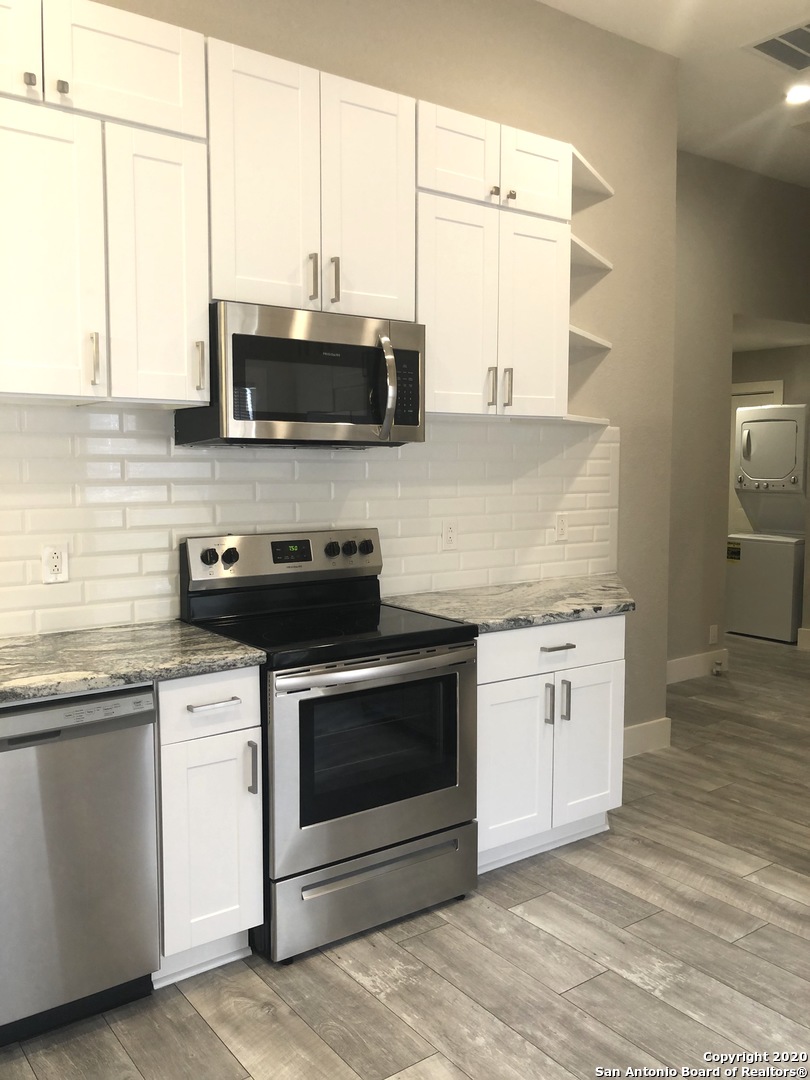 603 Devine Street, Unit 2 San Antonio, TX 78210 - Photo 8 of 16 a kitchen with stainless steel appliances white cabinets and a granite counter tops