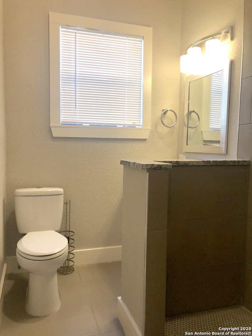 603 Devine Street, Unit 2 San Antonio, TX 78210 - Photo 10 of 16 a bathroom with a toilet sink and mirror
