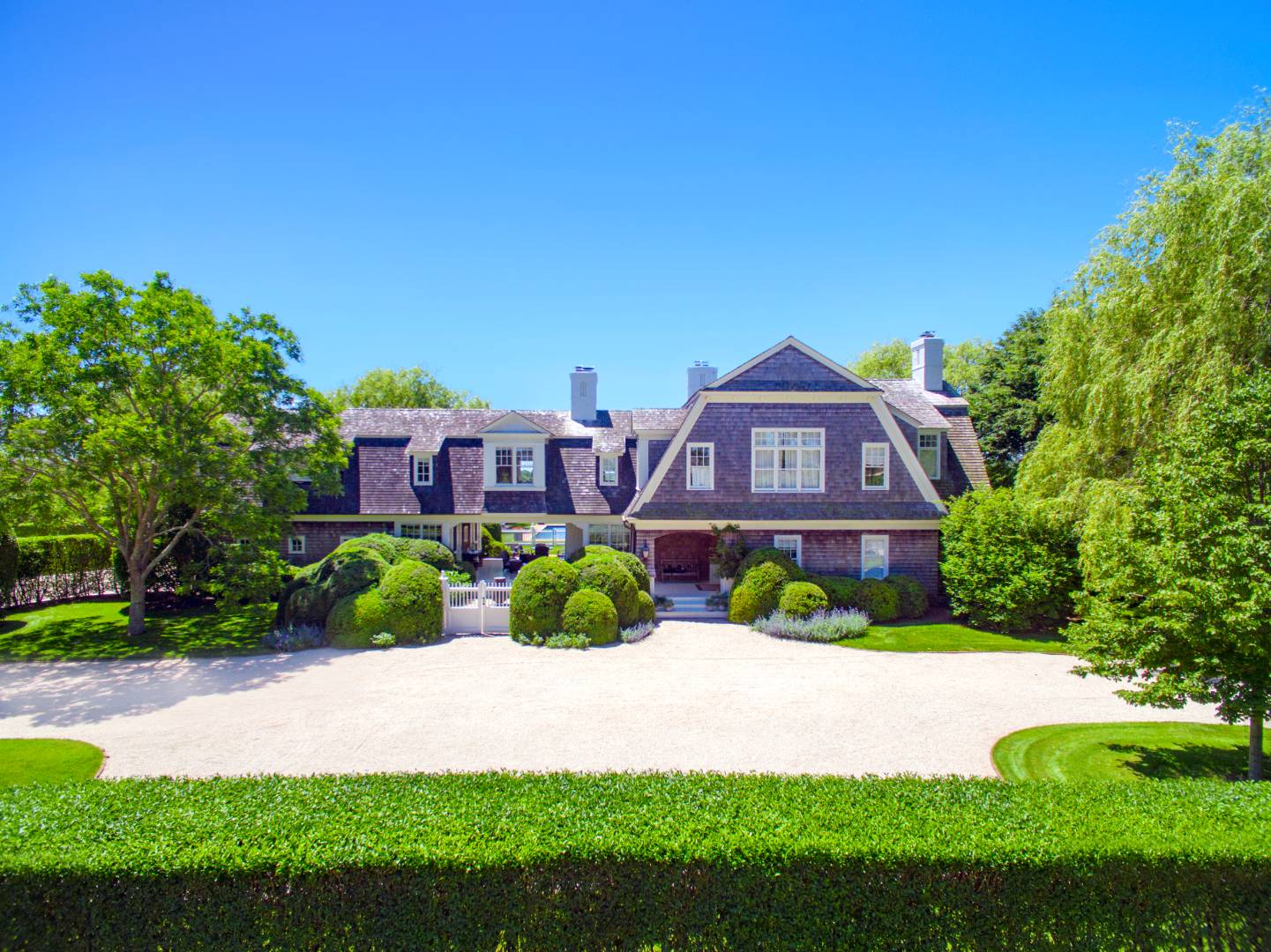 10 Dannielles Way Bridgehampton, NY 11976 - Photo 23 of 27 a front view of a house with a yard and potted plants