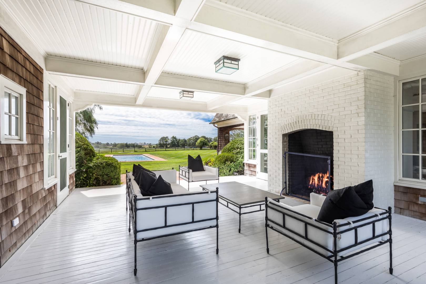 10 Dannielles Way Bridgehampton, NY 11976 - Photo 6 of 27 a living room with patio furniture and a fireplace