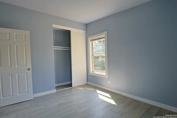 an empty room with windows and closet