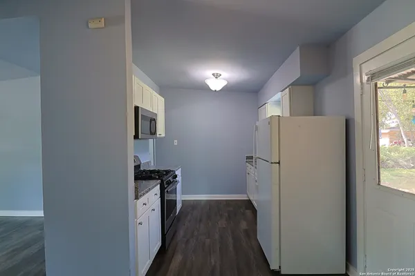 a view of hallway with wooden floor and electronic appliances