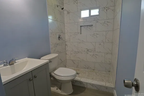a bathroom with a sink a toilet and shower