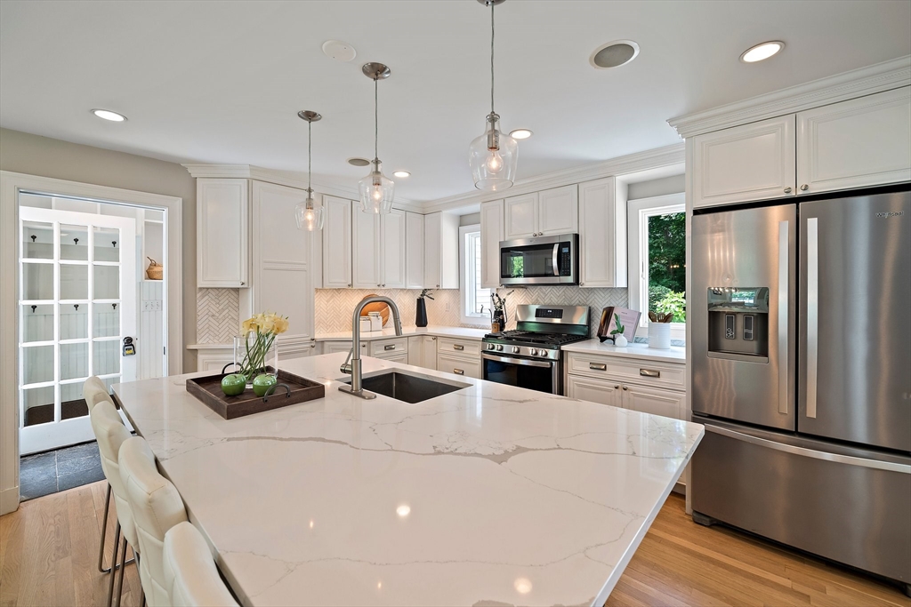 23 Regina Road Newton, MA 02466 - Photo 2 of 42 a kitchen with a refrigerator a stove a microwave oven a sink a dining table and chairs
