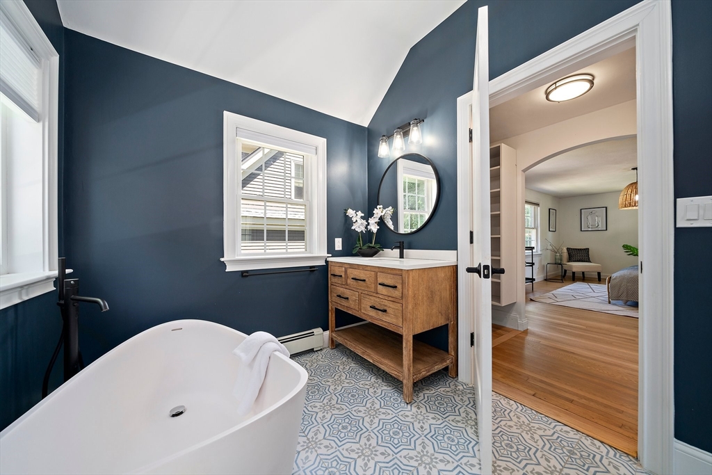 23 Regina Road Newton, MA 02466 - Photo 22 of 42 a spacious bedroom with a bed a mirror and a window