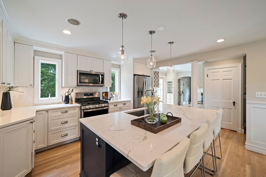 23 Regina Road Newton, MA 02466 - Photo 3 of 42 a kitchen with a stove a refrigerator a sink dishwasher a dining table and chairs with wooden floor