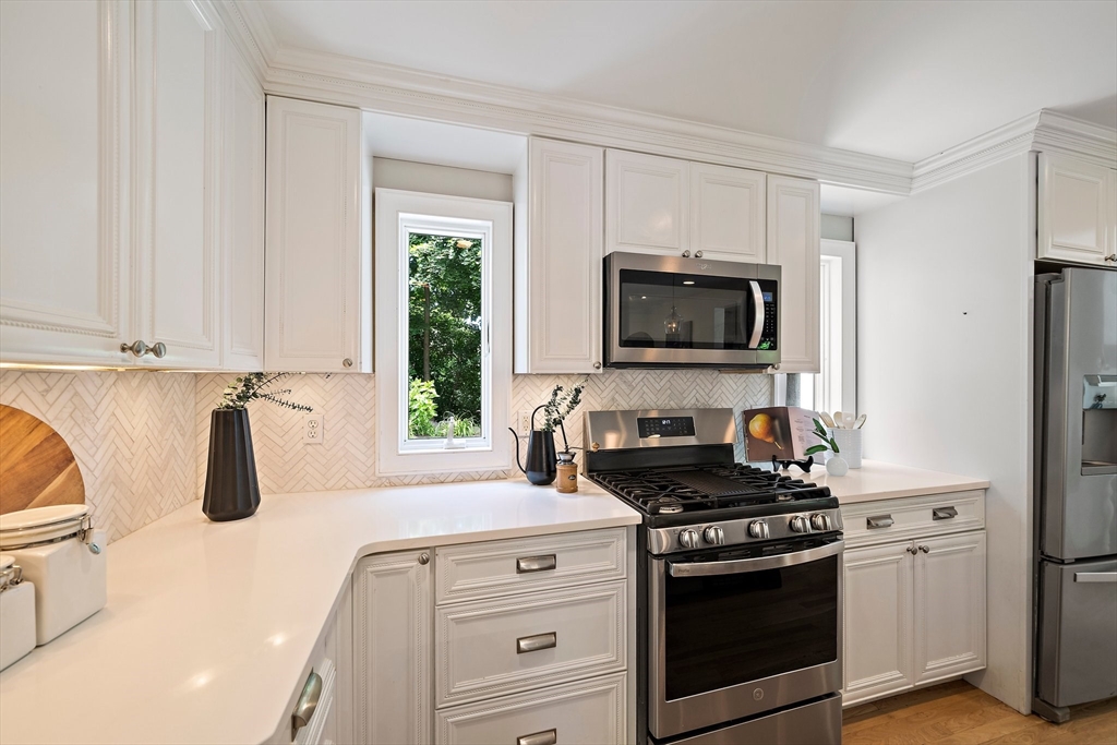 23 Regina Road Newton, MA 02466 - Photo 6 of 42 a kitchen with stainless steel appliances granite countertop a stove a microwave and a refrigerator