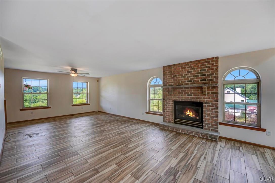 2242 Hill Road Effort, PA 18330 - Photo 4 of 50 an empty room with windows fireplace and wooden floor