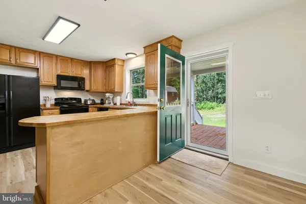 a living room with stainless steel appliances furniture a dining table and a flat screen tv