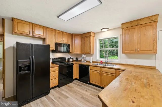 a kitchen with a sink cabinets and wooden floor