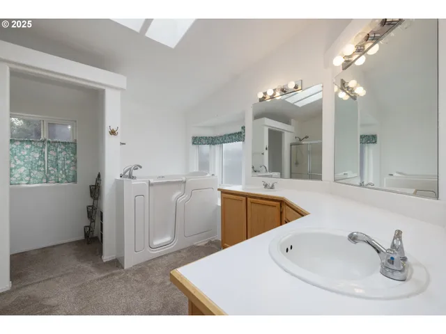 a en suite bathroom with a double vanity sink a mirror and a bathtub