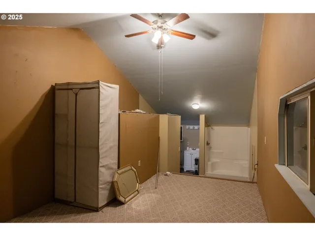 a view of a refrigerator in kitchen and an empty room