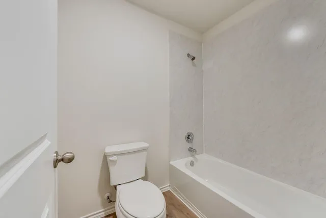 a white toilet and tub sitting next to a bathroom sink