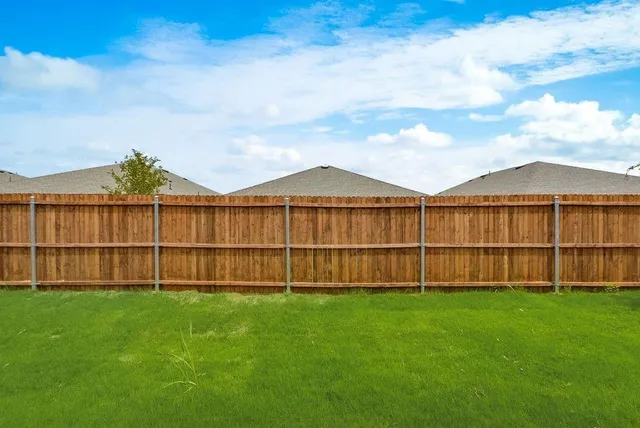 a view of yard with small swimming pool and wooden fence