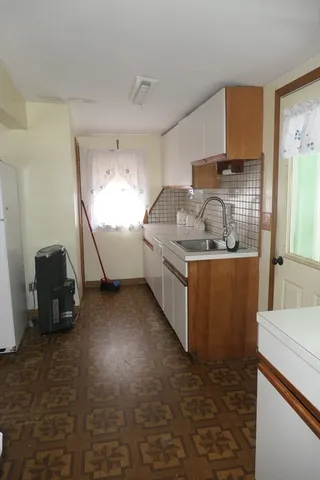 a kitchen with stainless steel appliances kitchen island granite countertop a sink a stove a refrigerator a washer and dryer