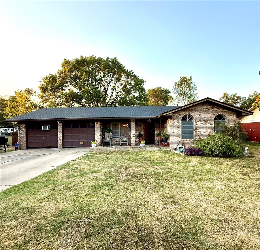 507 Sams Street Taylor, TX 76574 - Photo 1 of 1 Single story home with a front lawn, driveway, brick siding, and a garage