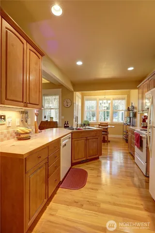 a large kitchen with kitchen island a large counter top space a sink stainless steel appliances and cabinets