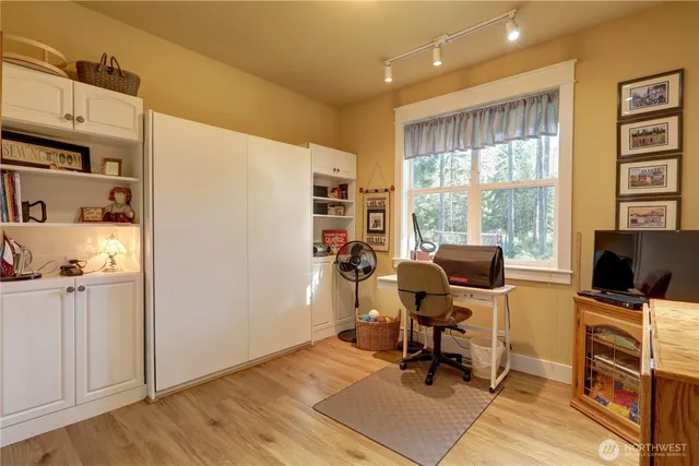 a view of a workspace with furniture and a window