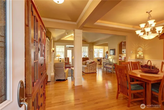 a view of a dining room and livingroom with furniture wooden floor a chandelier