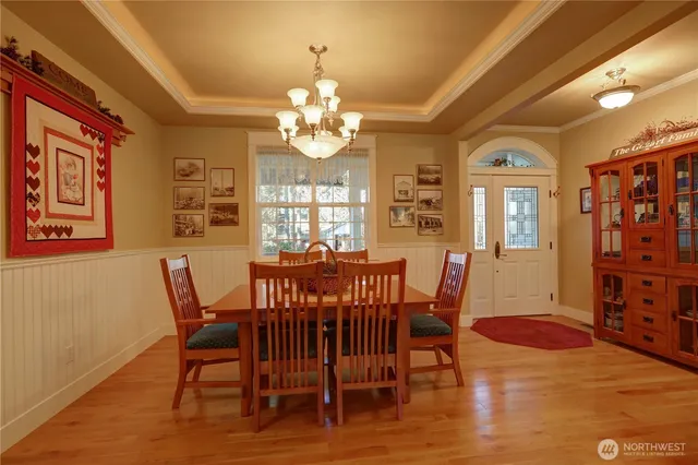 a view of a dining room with furniture a chandelier and wooden floor
