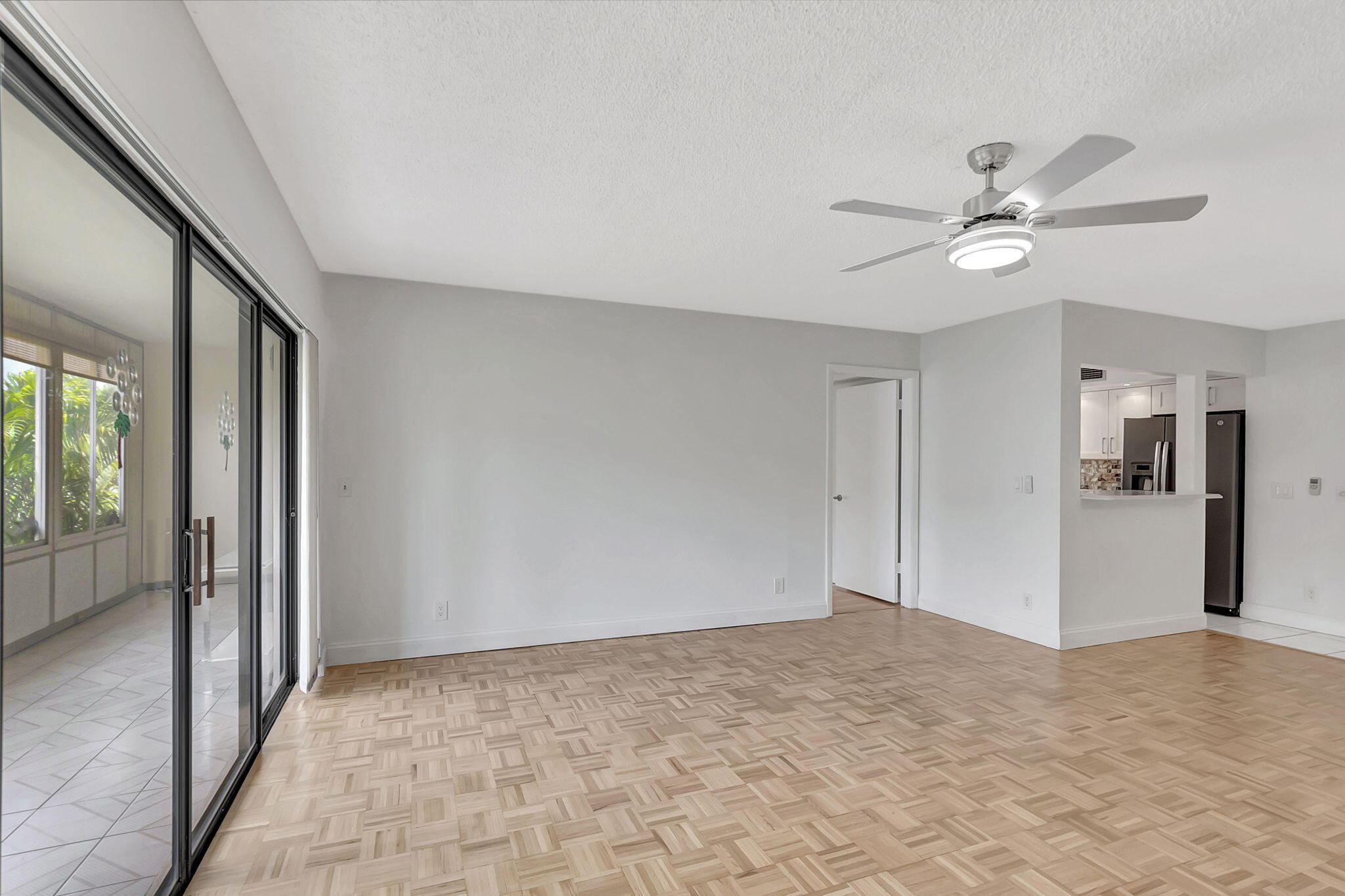 124 Capri B Delray Beach, FL 33484 - Photo 13 of 69 a view of a big room with wooden floor and a ceiling fan