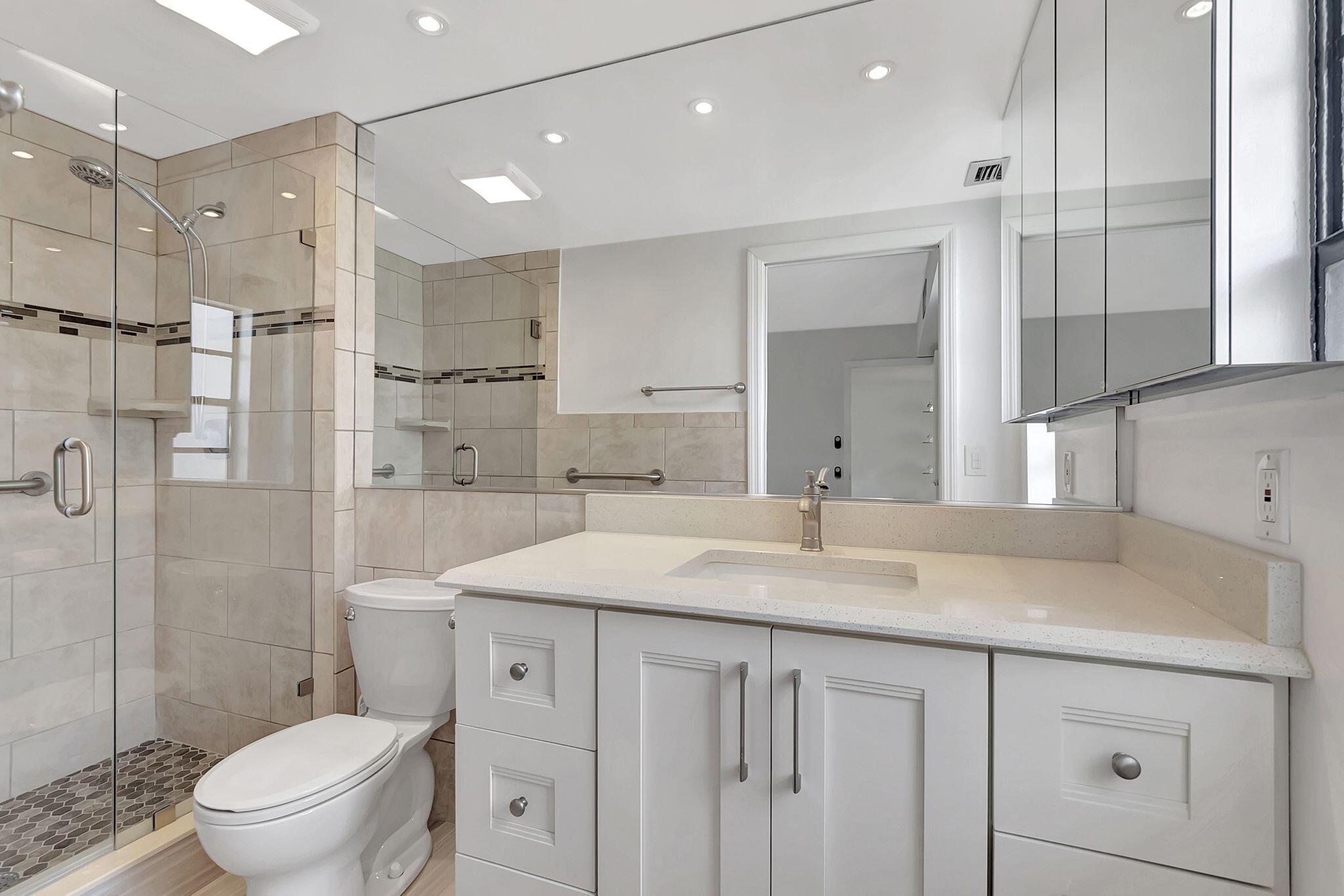 124 Capri B Delray Beach, FL 33484 - Photo 21 of 69 a bathroom with a sink a toilet a large mirror and shower