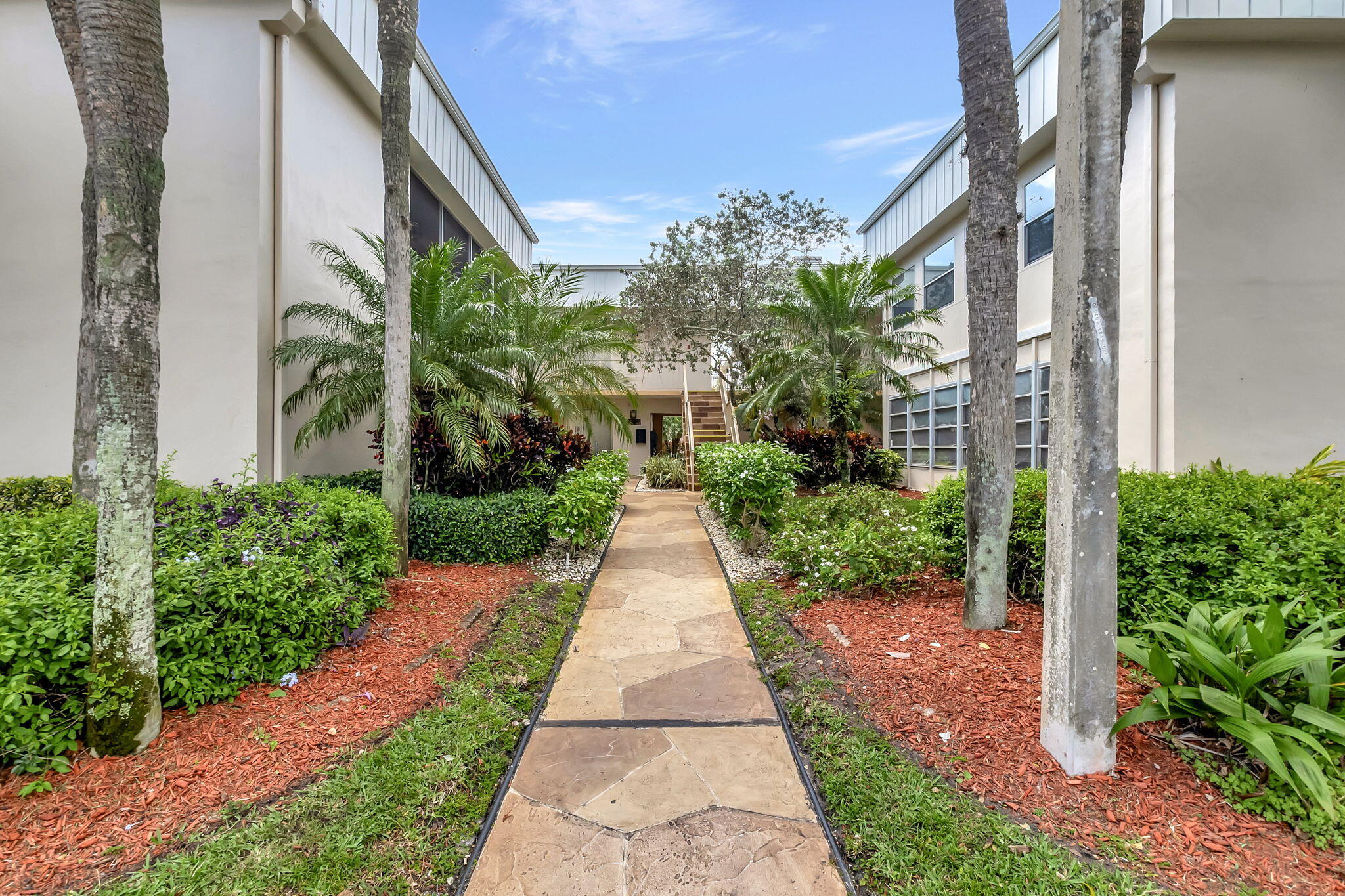 124 Capri B Delray Beach, FL 33484 - Photo 4 of 69 a view of a pathway with house on both side
