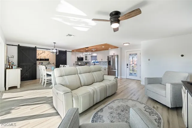 a living room with furniture and a ceiling fan