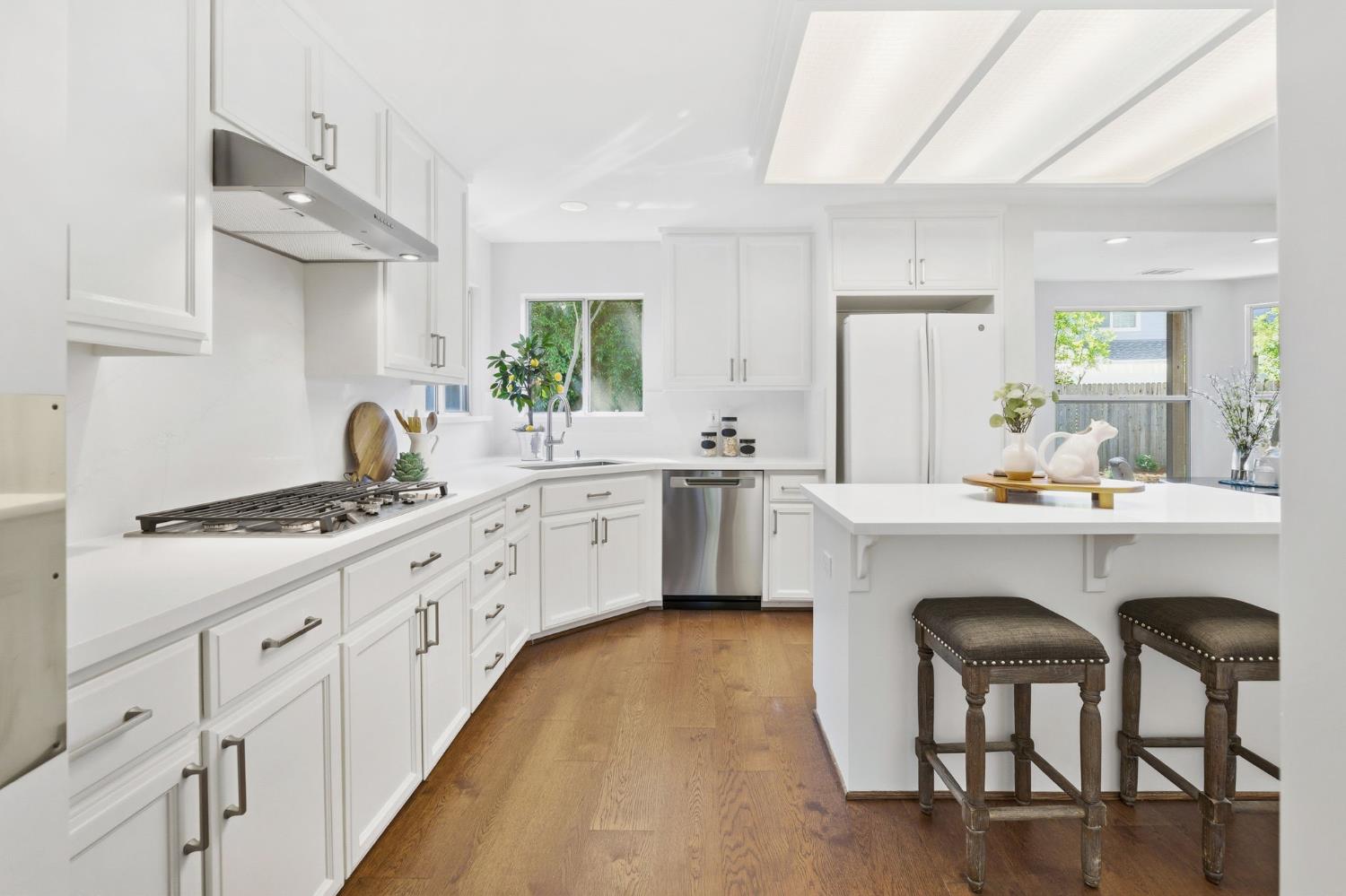 3718 Maidu Place Davis, CA 95618 - Photo 13 of 50 a kitchen with white cabinets and chairs