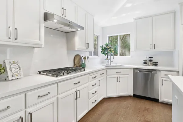 a kitchen with white cabinets and appliances