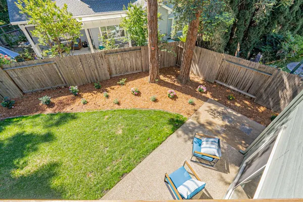 a view of backyard with seating space and trees