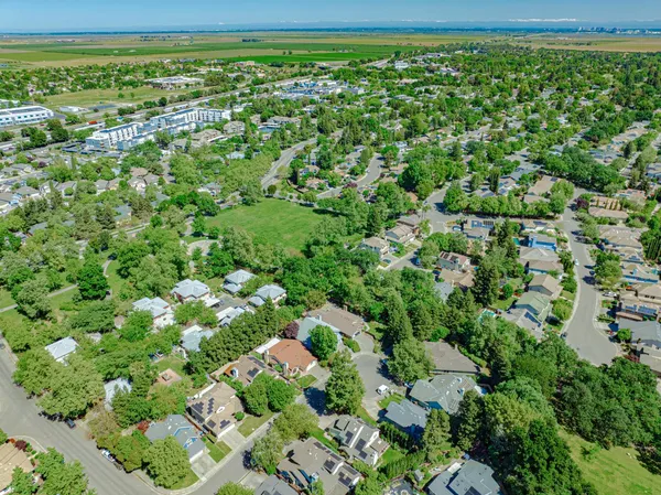 an aerial view of residential house with outdoor space and trees all around