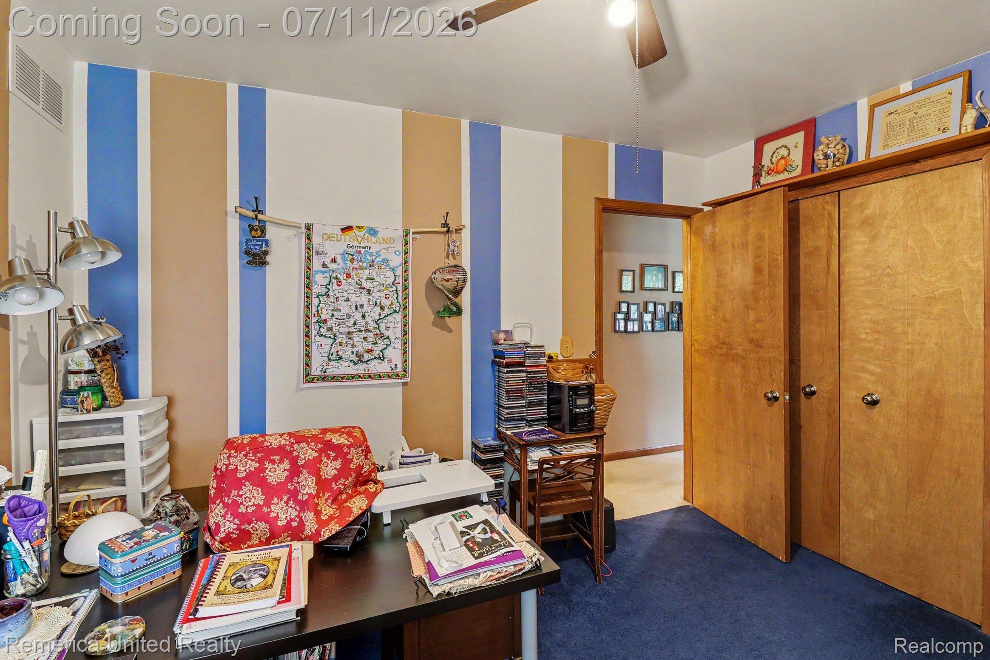 136 Endicott Howell, MI 48843 - Photo 14 of 28 Room featuring wood-finish double bi-fold doors, blue carpeting, and a ceiling fan