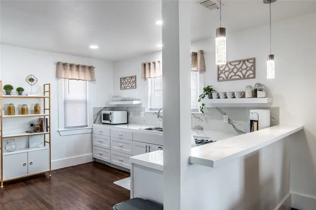a kitchen with kitchen island white cabinets and refrigerator