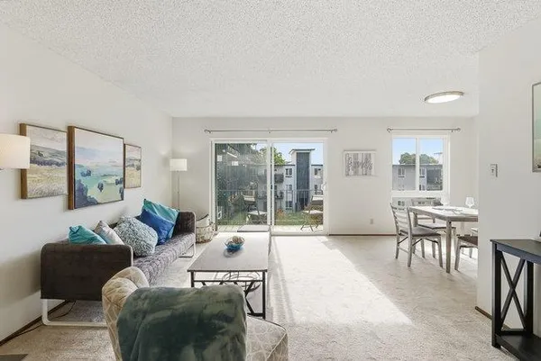a living room with furniture and a large window with balcony view